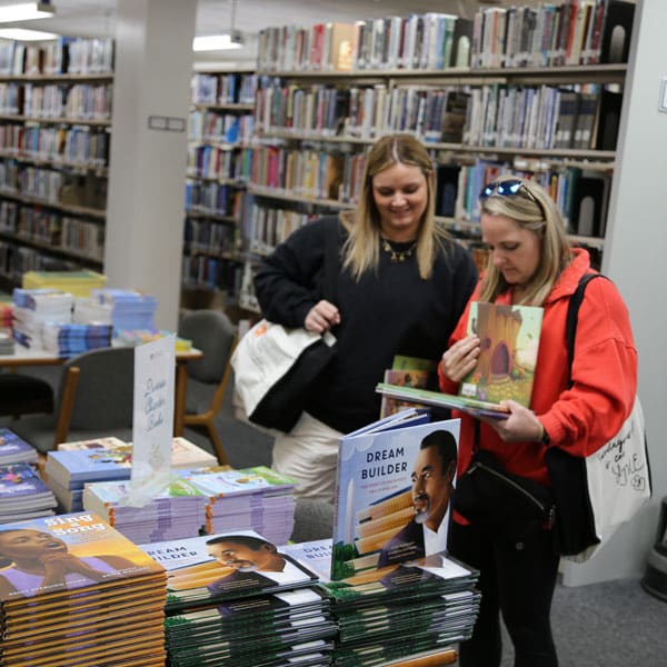 Conference attendees browse children's books.