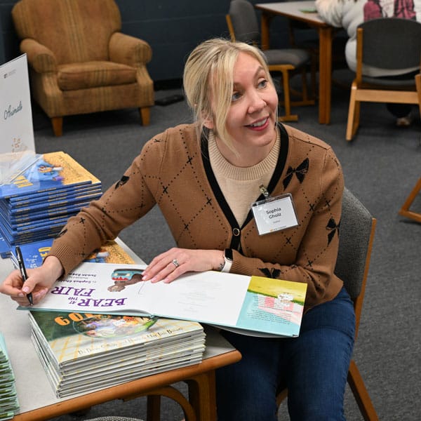 Sophia Gholz signing books.