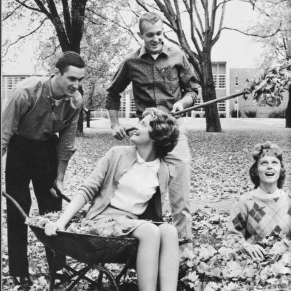A black-and-white photo showing students on campus in the fall.