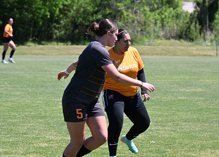 Two opponents during the alumni soccer match.