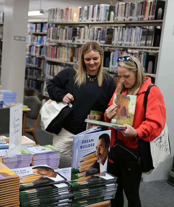 Conference attendees browse children's books.